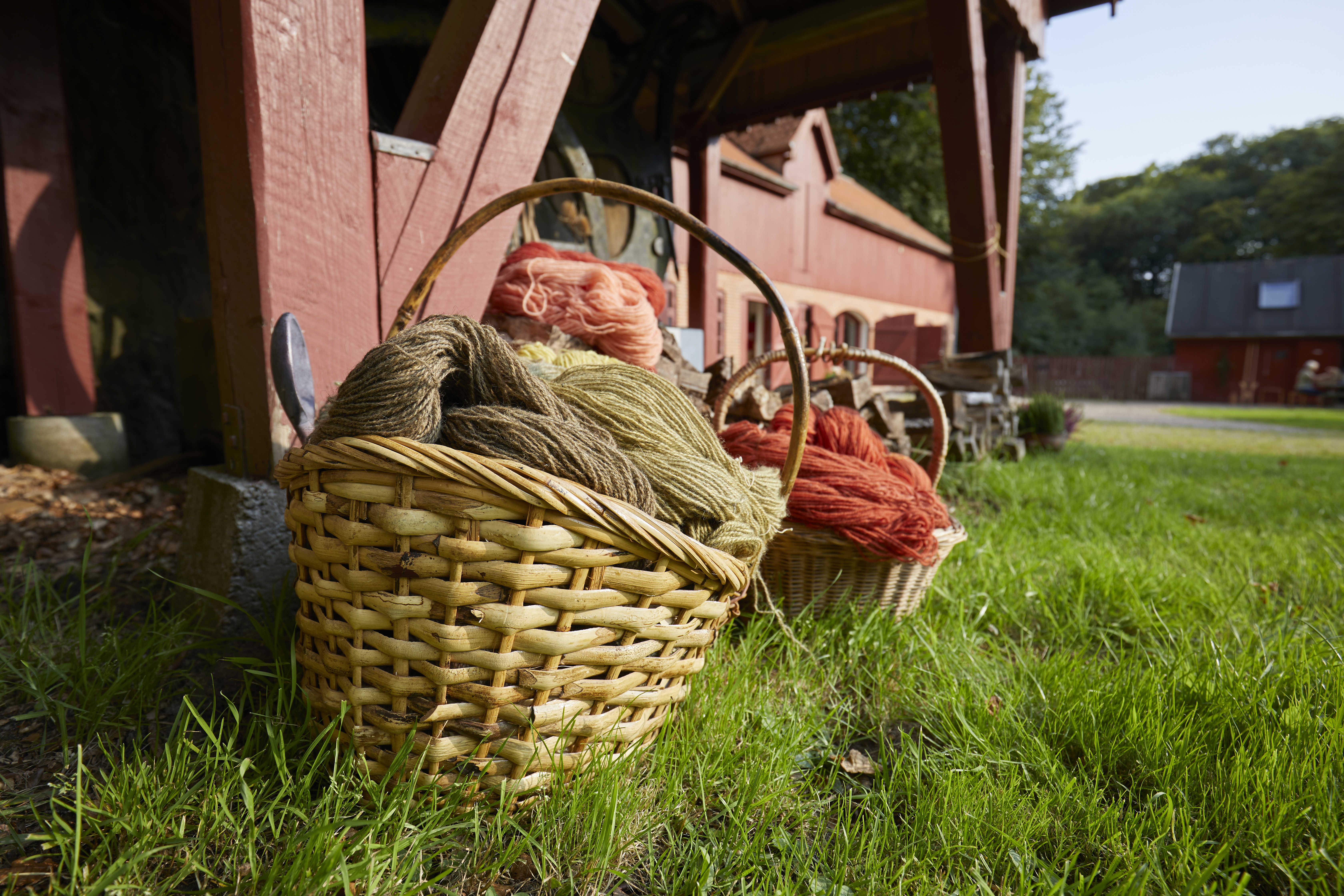 Kurve med håndfarvet garn foran Randbøldalmuseet